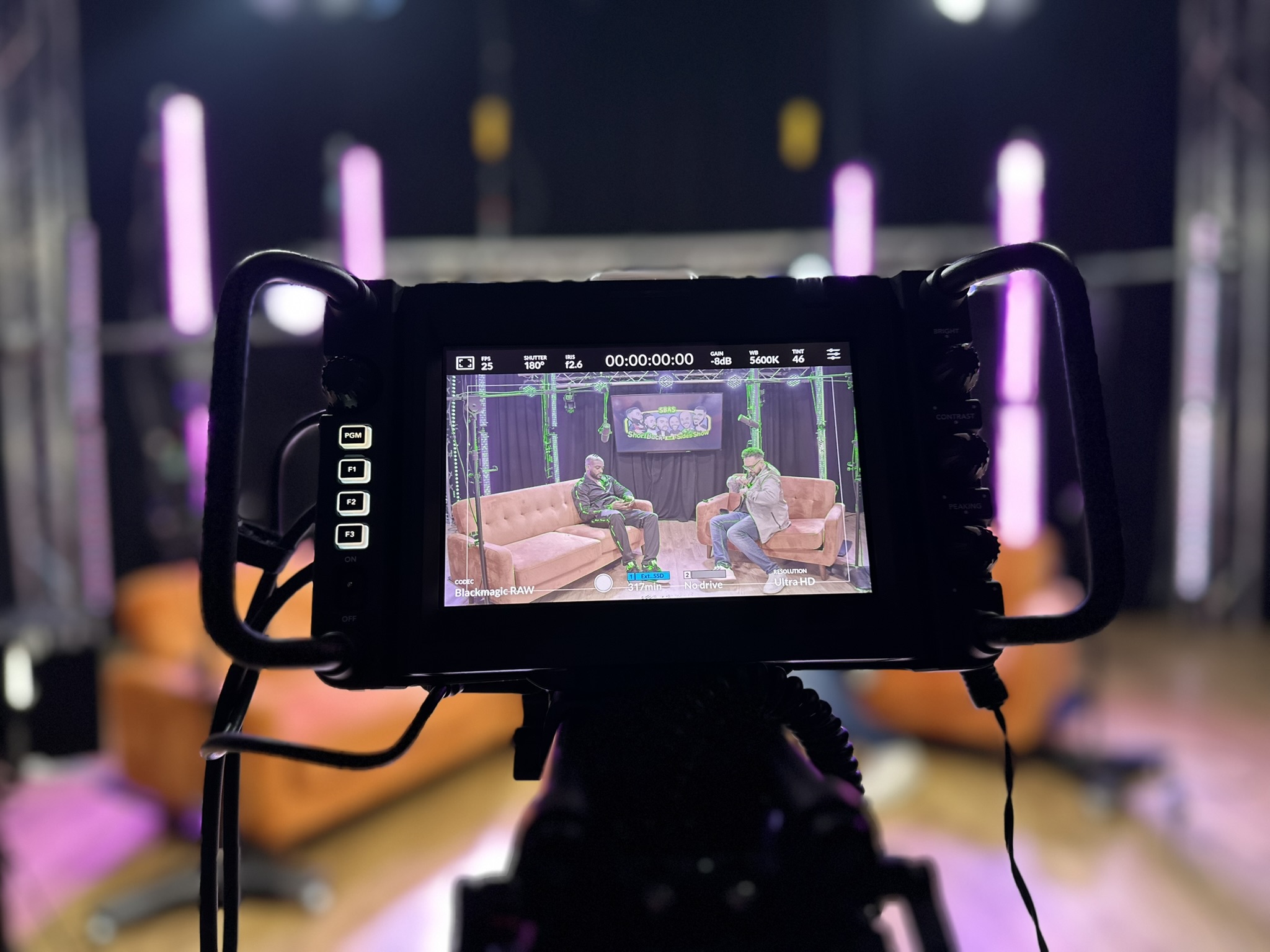 Blackmagic camera monitor framing two presenters during a podcast recording in the Leicester studio