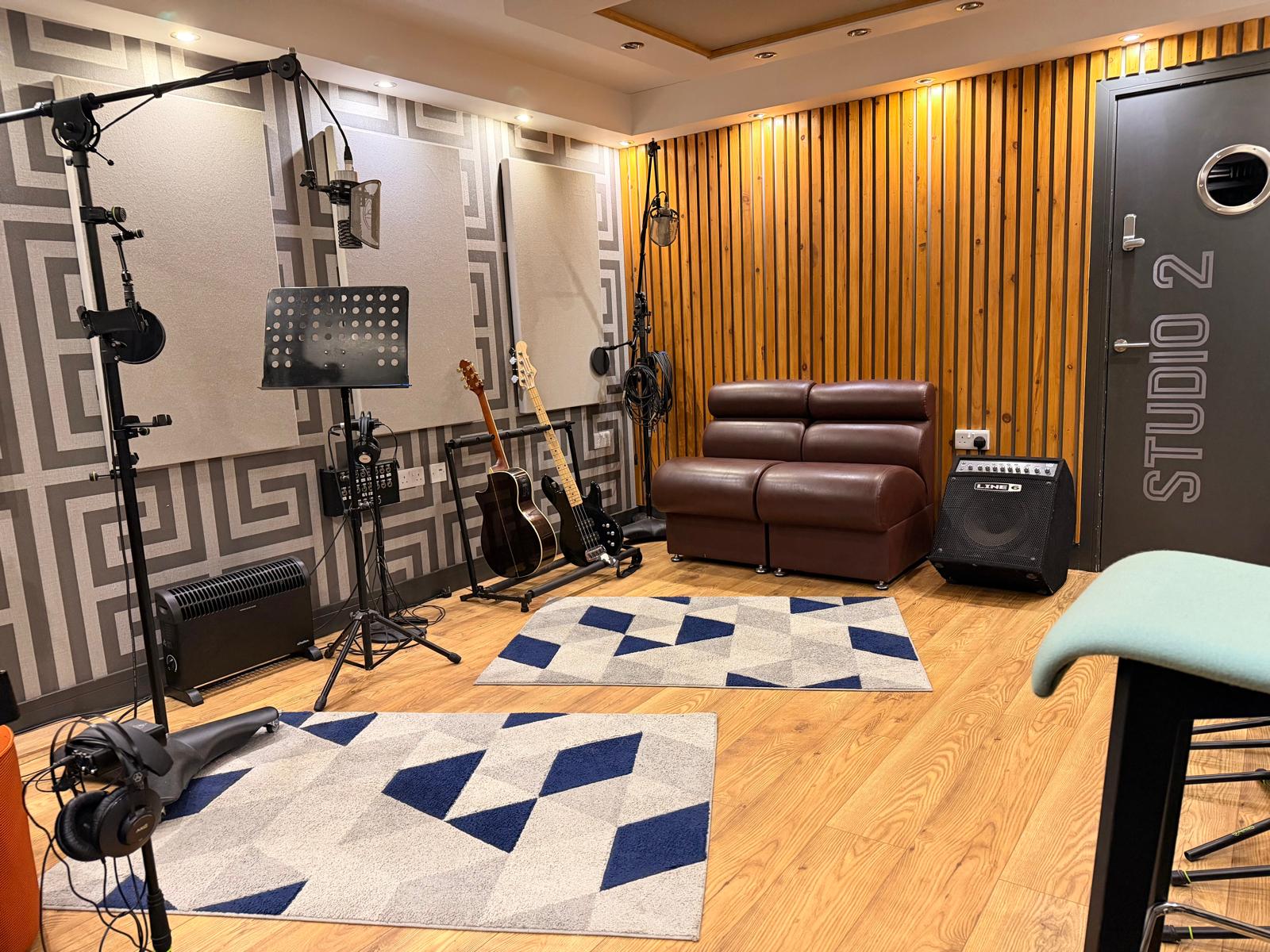 Studio 1 audio production room at TubbyStudios with microphones, acoustic wall panels and upright timber treatment